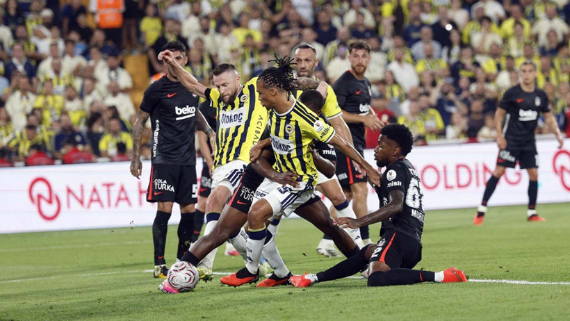 Beşiktaş ve Fenerbahçe futbolcularının maç sırasında mücadele ettiği görüntü.