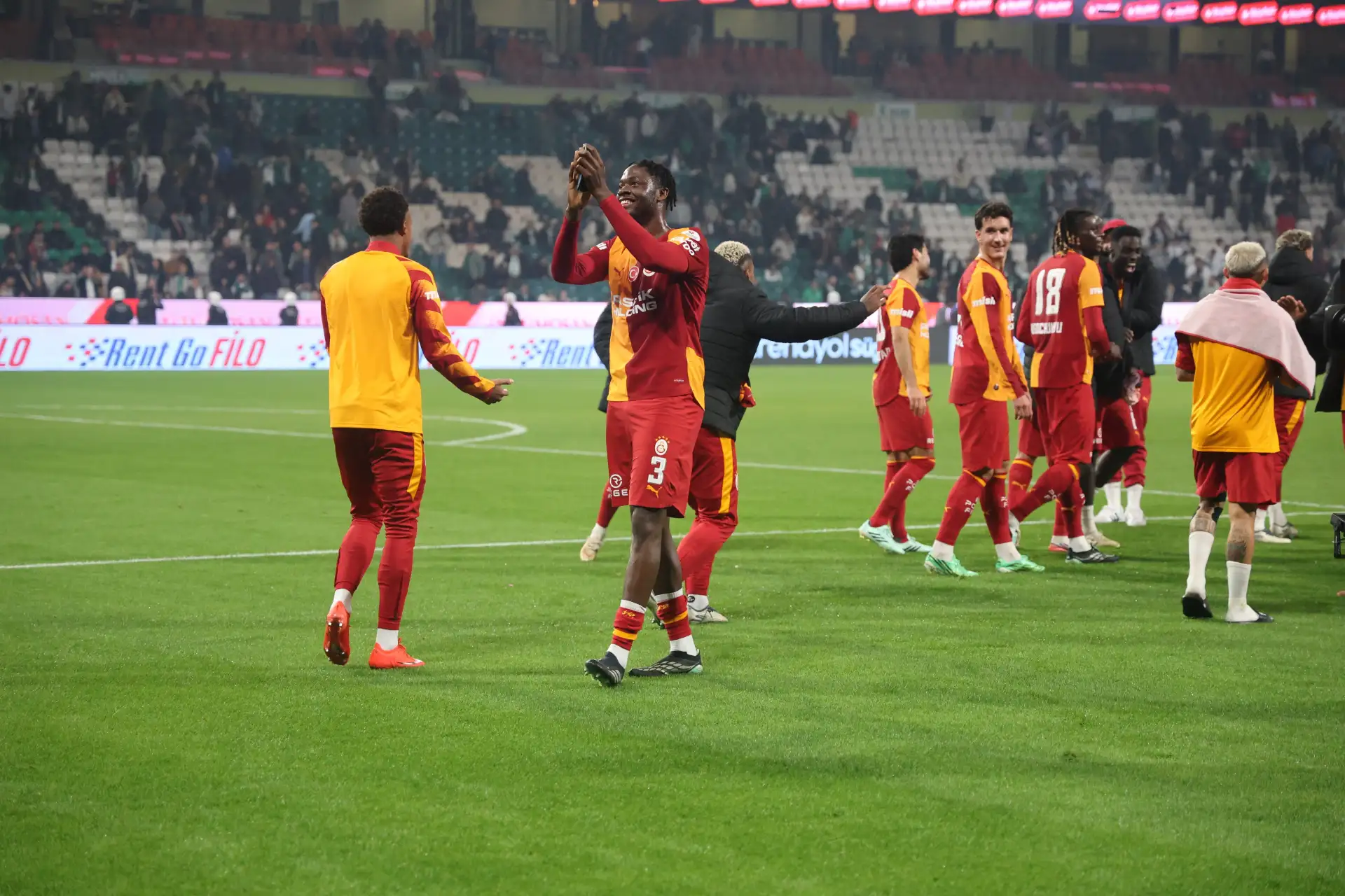Galatasaray players are seen greeting the fans on the pitch at the end of the match.