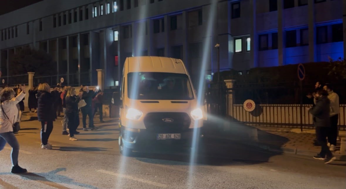 Gece saatlerinde Denizli Adalet Sarayı önünden çıkan bir araç ve çevrede bekleyen vatandaşlar.