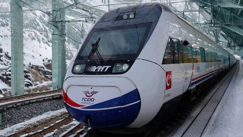 Karlı dağlık bölgede istasyonda duran yüksek hızlı tren.