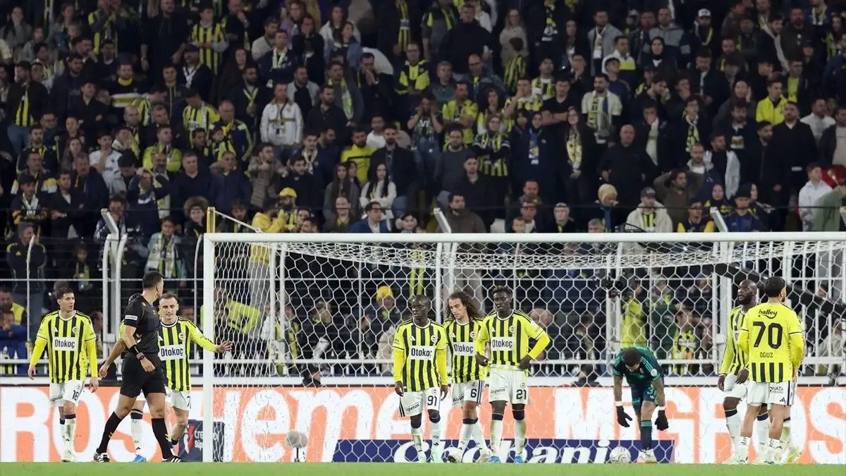 Fenerbahçeli futbolcuların sahada, tribünlerdeki taraftarların ise arka planda görüldüğü maç görüntüsü.