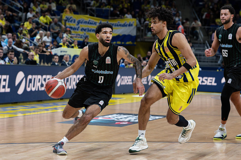Biotekno Körfez Basket oyuncusu top sürerken Fenerbahçe Tarfinli oyuncular savunmada.