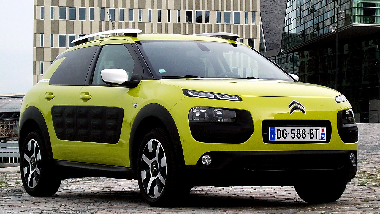Şehir ortamında park halindeki sarı renkli Citroen otomobil.