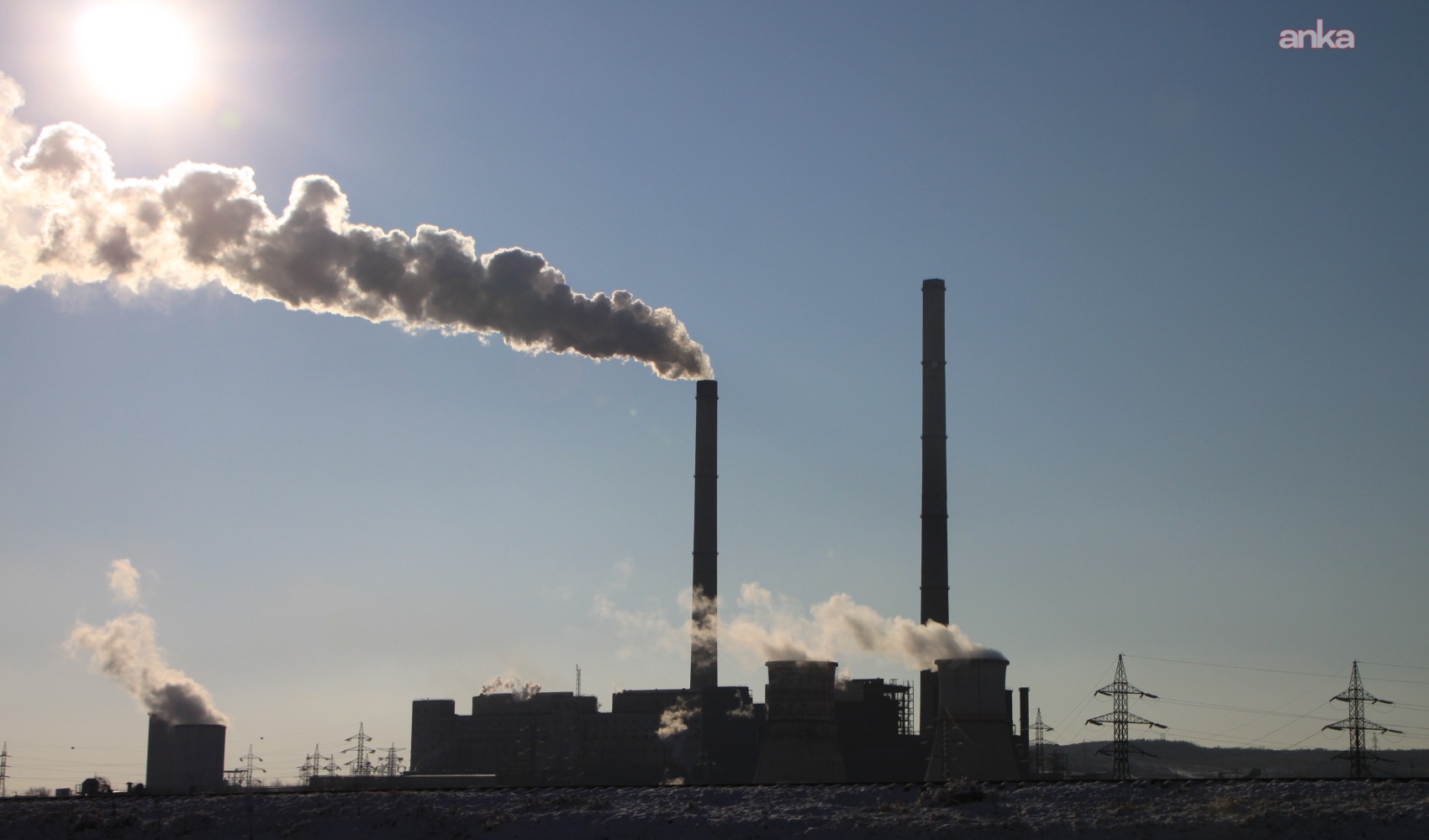 Immagine ambientale generale che mostra un impianto industriale con fumo che esce dai camini in una giornata soleggiata.