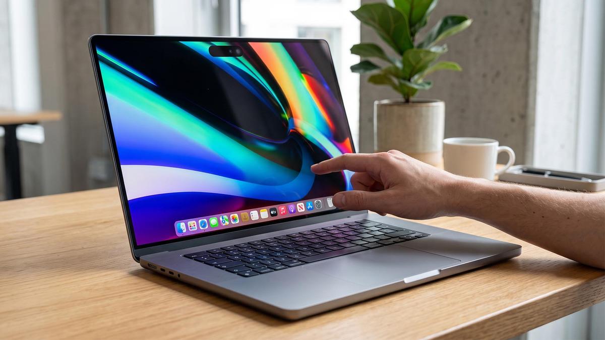 Une image montrant un concept de MacBook Pro où une personne touche l'écran de l'ordinateur portable.