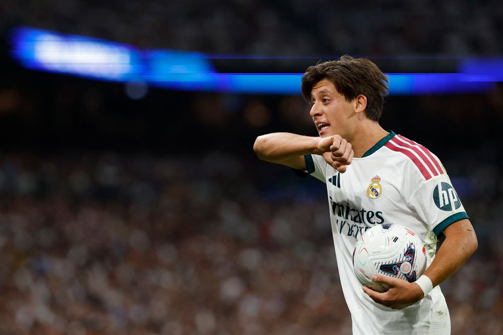 Real Madrid forması giyen Arda Güler maç sırasında topu elinde tutuyor.