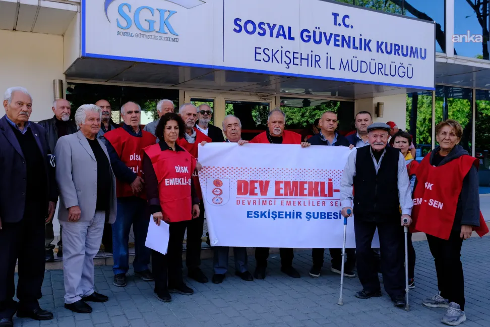 Des retraités et des représentants syndicaux tenant des banderoles devant la direction provinciale de la SGK à Eskişehir.