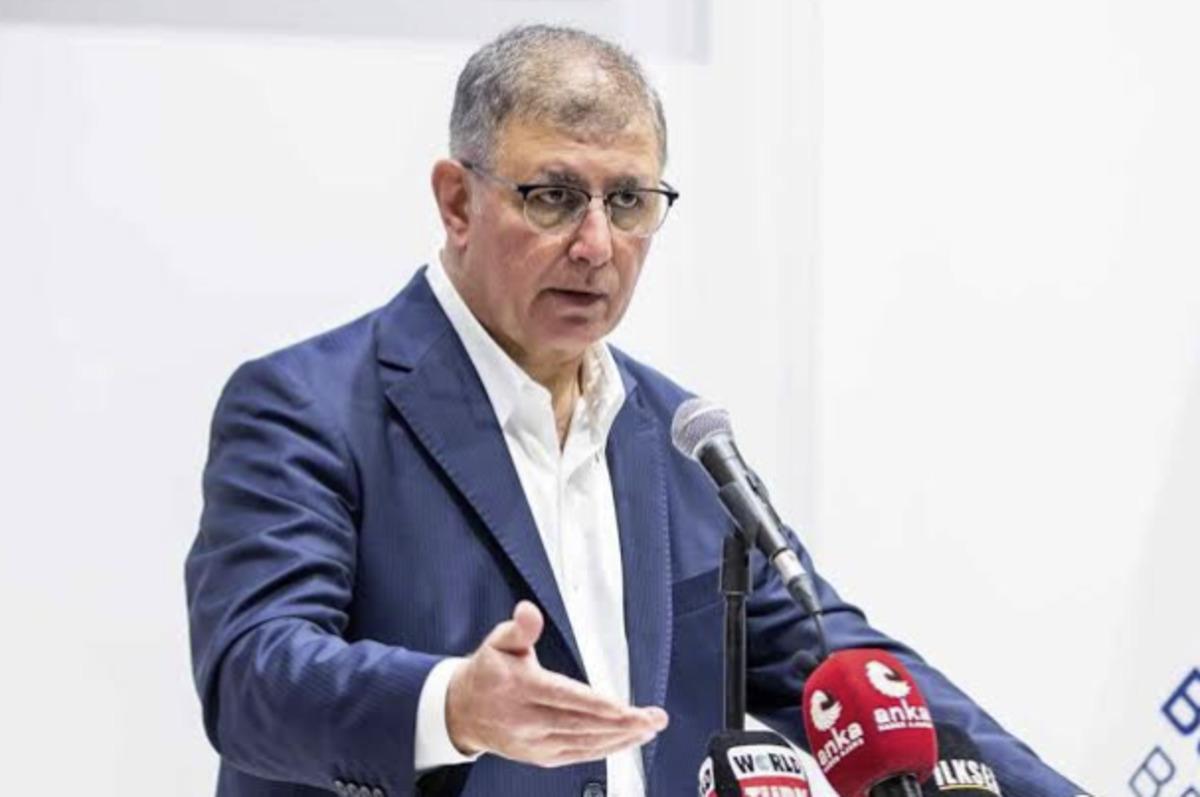 Cemil Tugay mikrofonlar önünde konuşurken görülüyor.