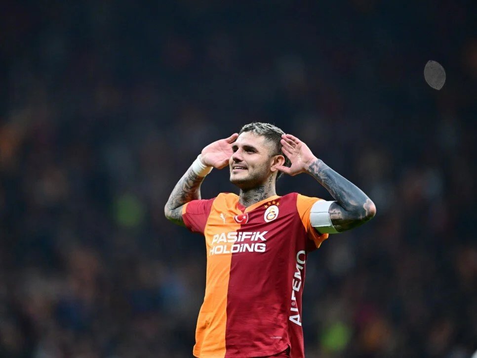 Galatasaray forması giyen Mauro Icardi sahada taraftarlara doğru ellerini kulaklarına götürerek seviniyor.