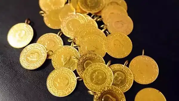 Siyah zemin üzerinde altın ziynet eşyaları.
