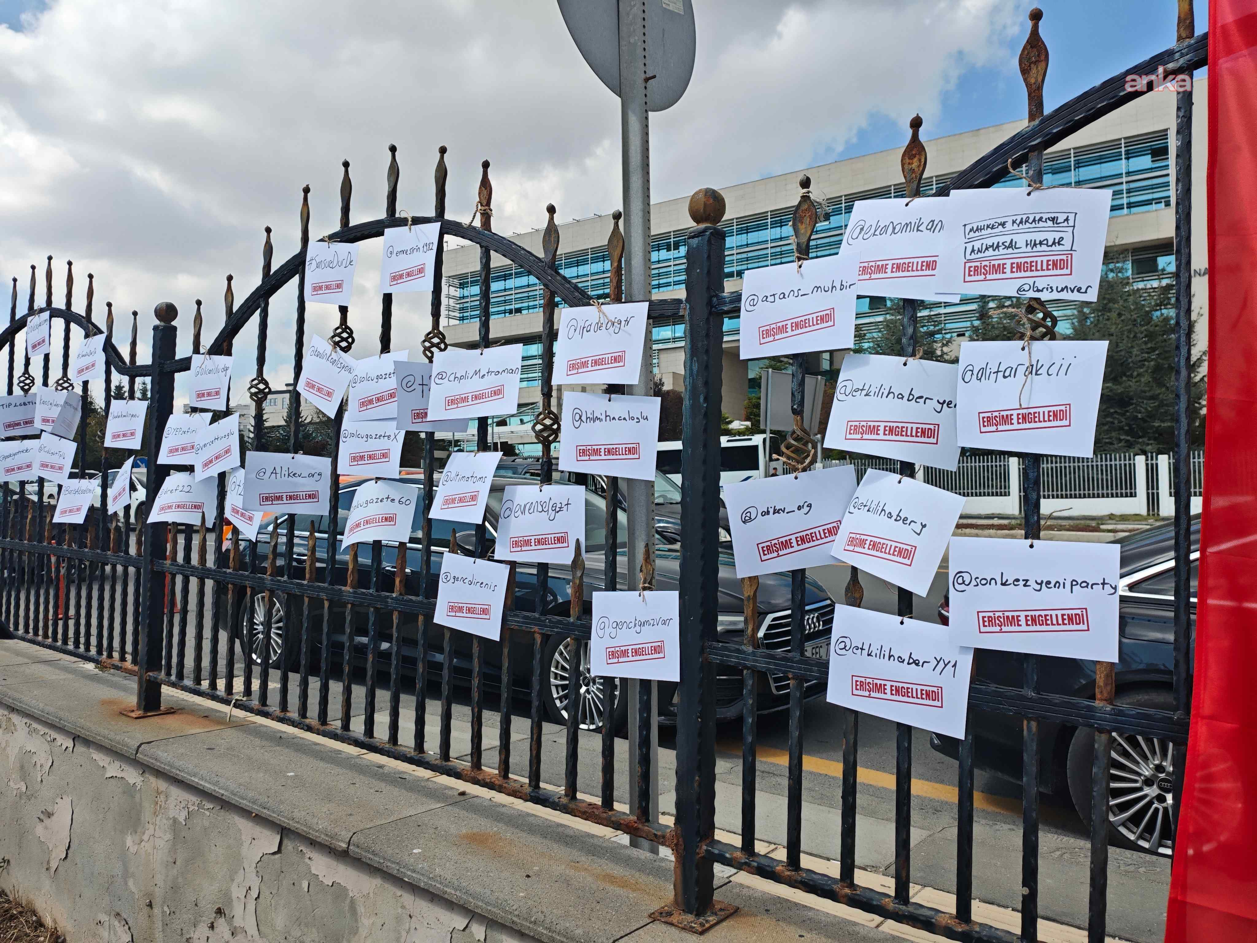 Social media account cards with 'access blocked' written on them, hung on the iron railings in front of the Constitutional Court.