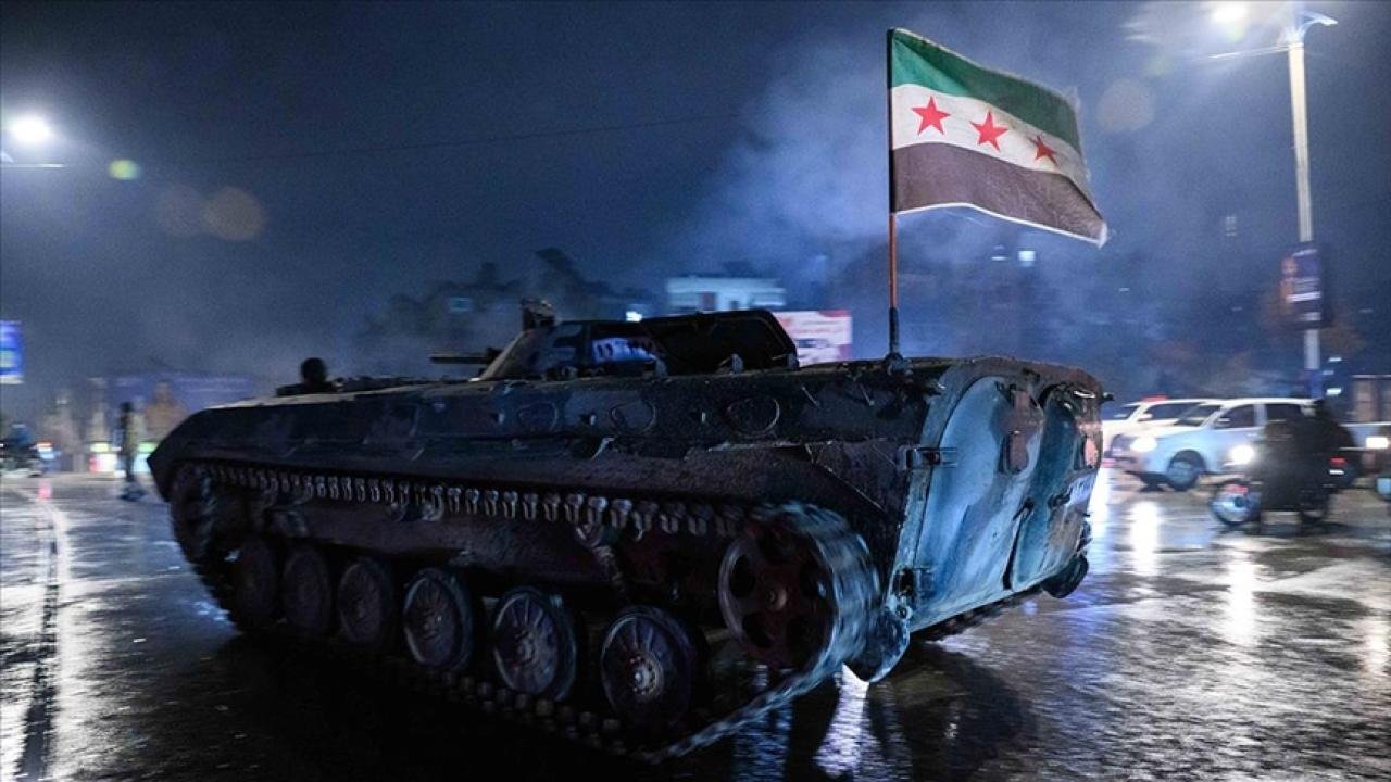 Suriye bayrağı taşıyan zırhlı aracın gece bir yolda ilerlediği görüntü.