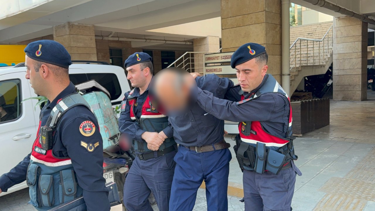 Jandarma ekiplerinin şüpheliyi adliye girişinde götürdüğü görüntü.