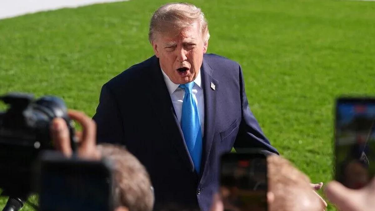 Donald Trump’ın açık alanda gazetecilerle konuştuğu bir fotoğraf.