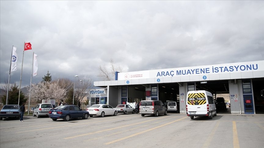 Araç muayene istasyonu önünde sıra bekleyen araçlar ve istasyon binası.