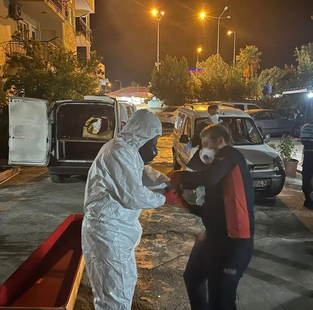 Work of teams in protective gear and officials around the guesthouse during the night hours.