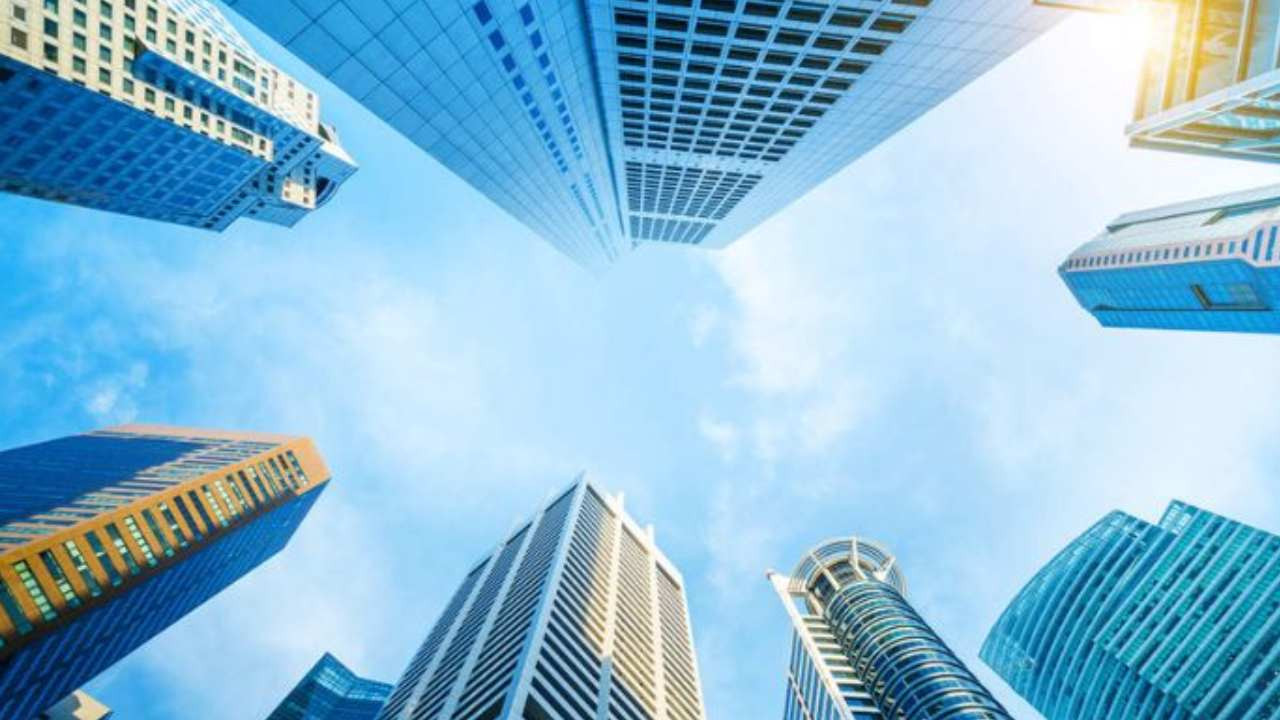 Yüksek katlı modern binaların aşağıdan gökyüzüne doğru görüldüğü şehir manzarası.