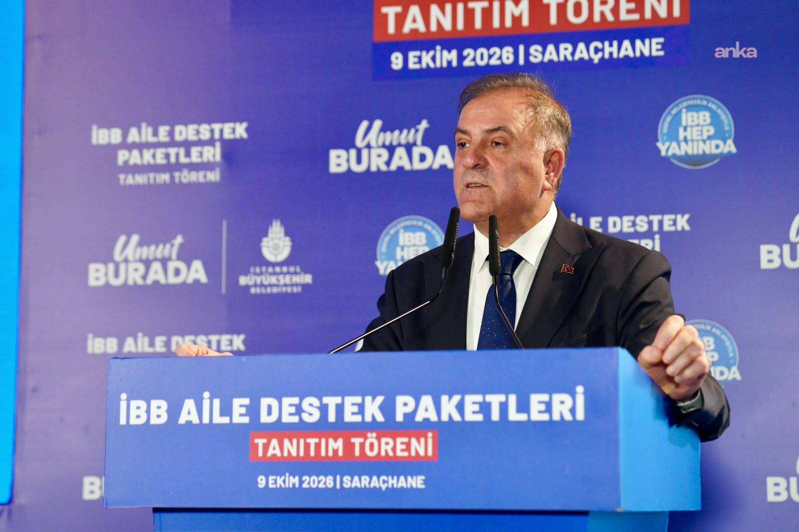 Nuri Aslan, mavi İBB arka planı önünde konuşma yapıyor.