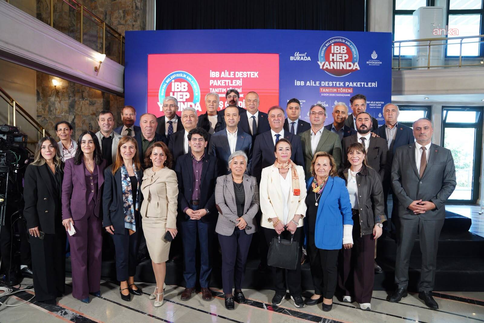 İBB Aile Destek Paketleri Tanıtım Töreni sonrası kalabalık bir grup sahne önünde poz veriyor.