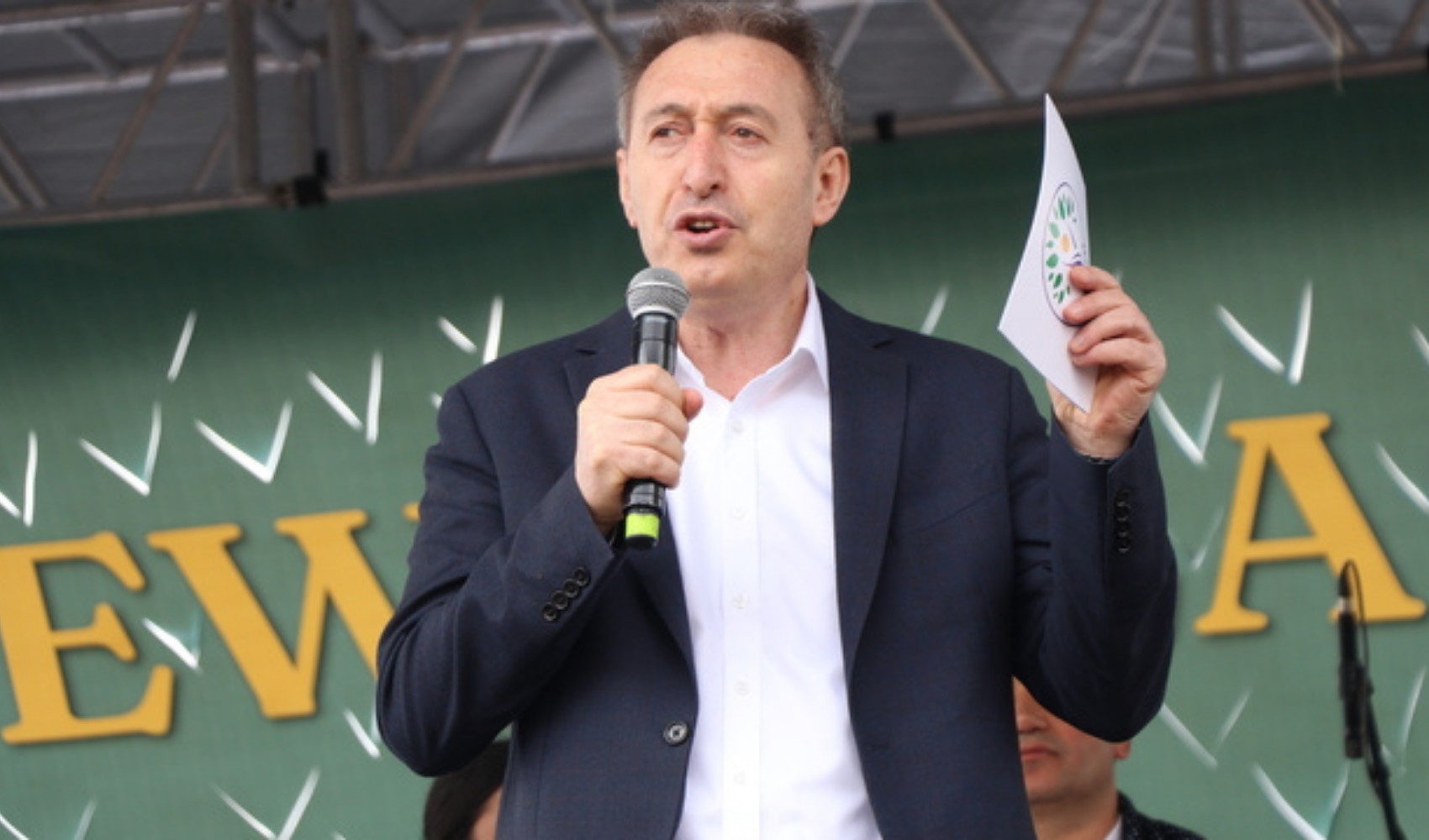 Tuncer Bakırhan mikrofonla konuşma yaparken görülüyor.