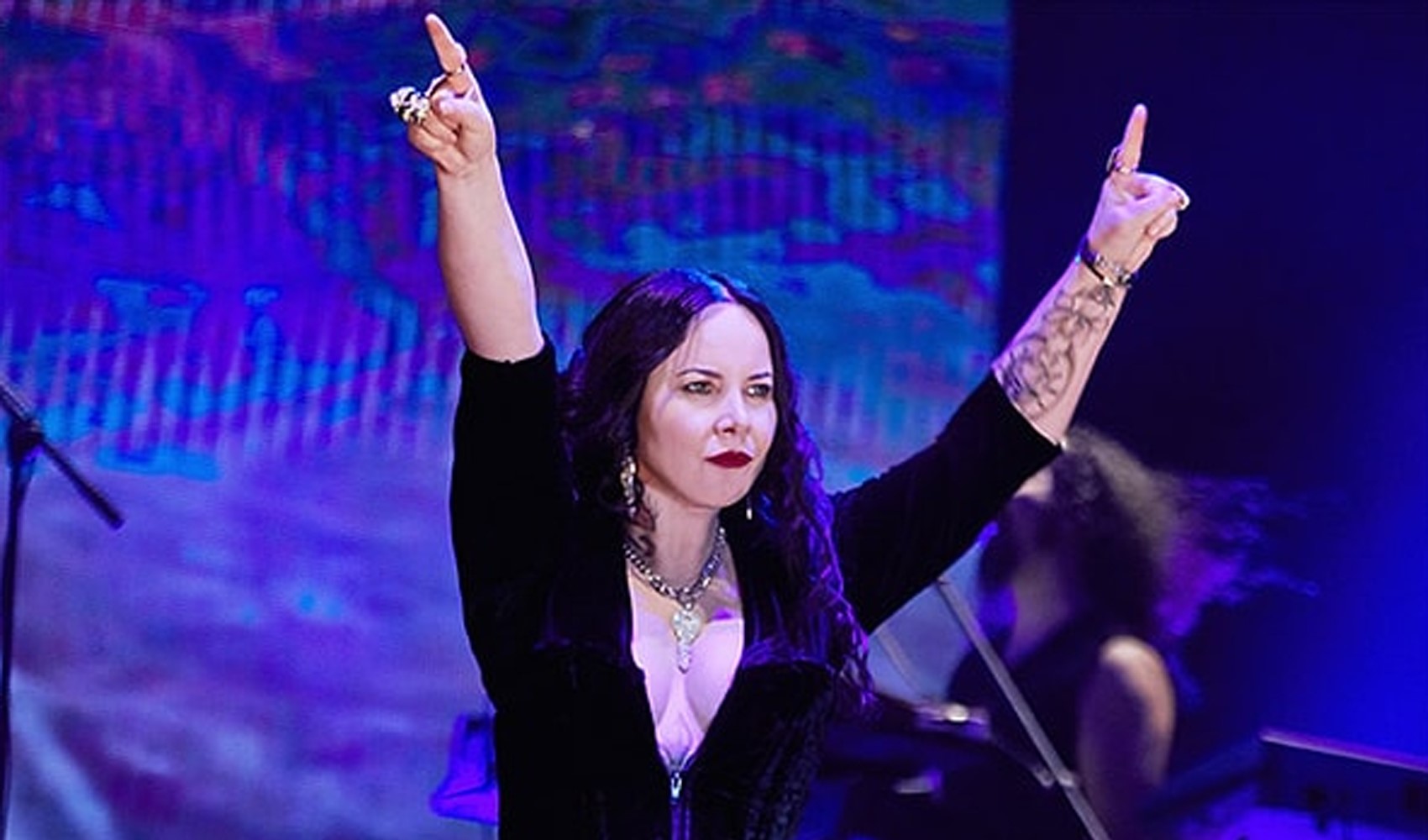 Sahnede performans sergileyen bir sanatçı ve konser ışıkları.