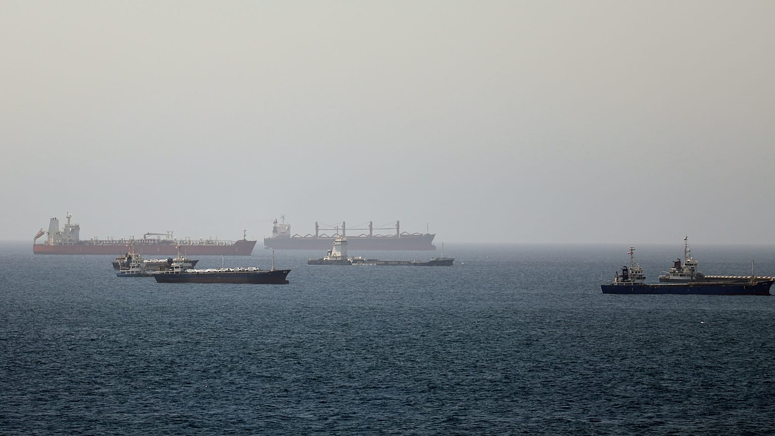 Denizde seyreden çok sayıda tanker ve yük gemisi görülüyor.