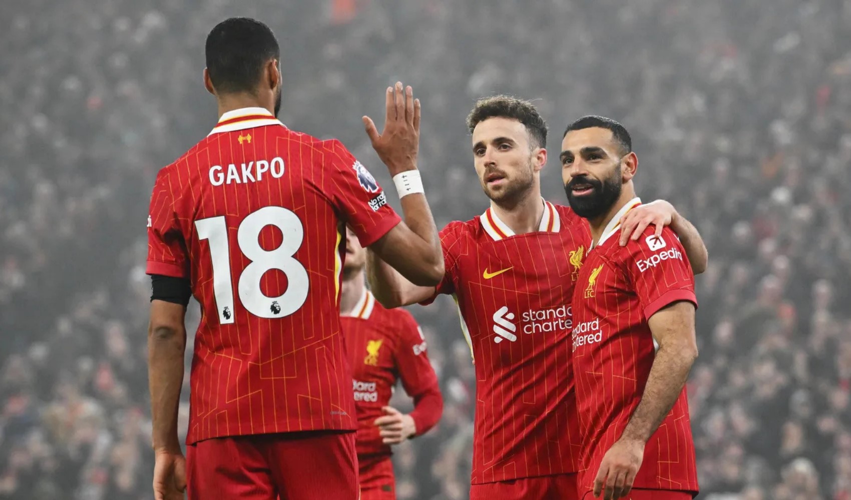Liverpool forması giyen futbolcular sahada kutlama yapıyor.