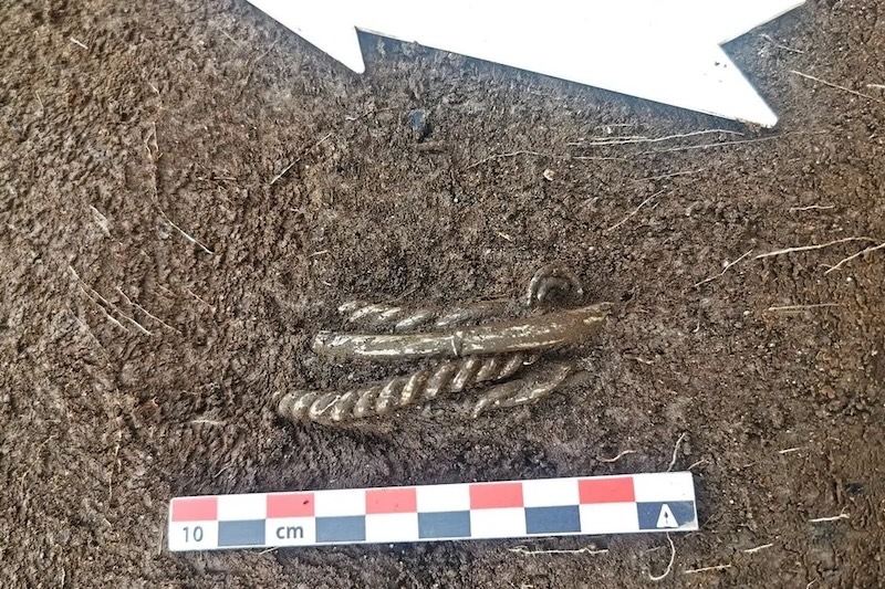 Toprakta yan yana görülen gümüş Viking bilezikleri.