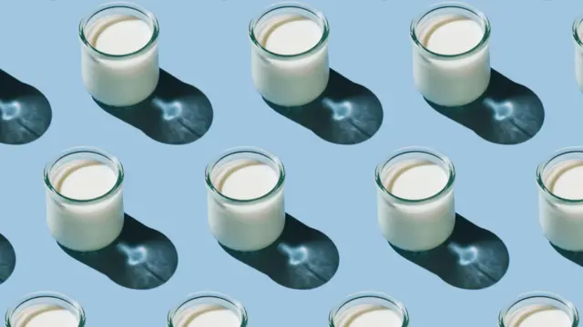 Soluk mavi bir arka plan üzerinde çapraz sıralanmış küçük kefir bardakları.