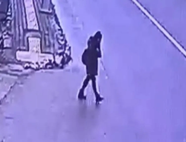 Güvenlik kamerası görüntüsünde yolda yürüyen bir kişi.