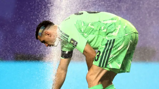 Arjantin kalecisi Emiliano Martinez, sahadaki fıskiyeyle serinliyor.