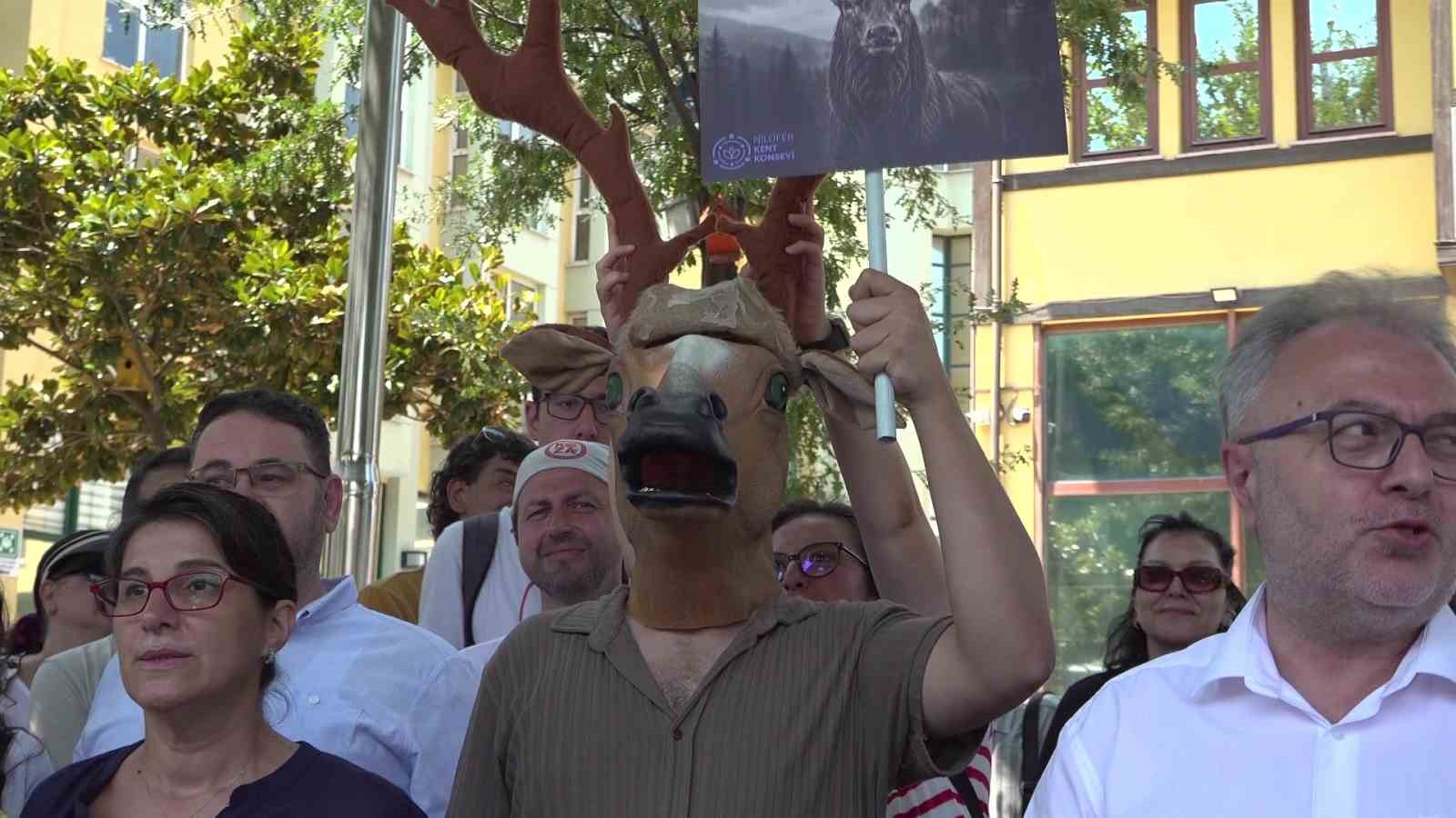 Geyik kostümü giymiş bir protestocu, kızıl geyik görselli döviz tutan katılımcılar arasında görülüyor.