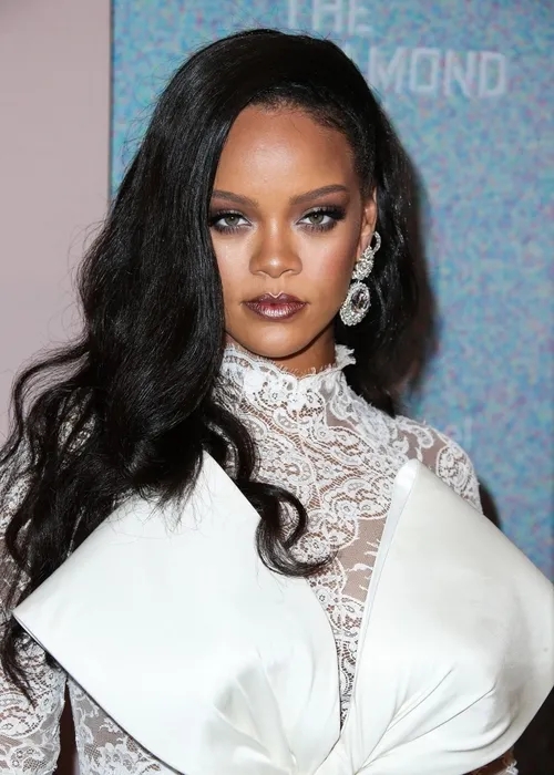 Rihanna'nın beyaz kıyafetle objektife baktığı portre fotoğrafı.