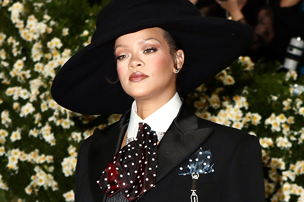 Rihanna'nın siyah şapka ve takım elbiseyle katıldığı bir etkinlikten fotoğrafı.