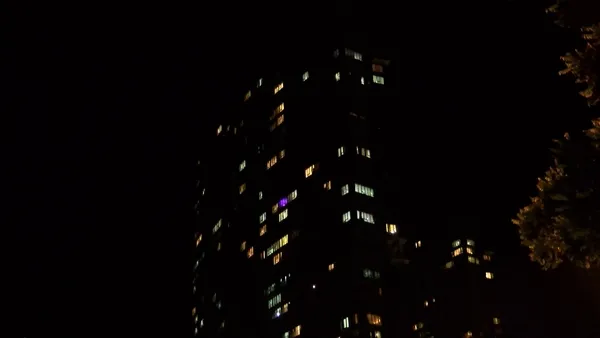 Gece saatlerinde ışıkları yanan yüksek katlı site binası.