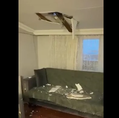 Bir evin salonunda tavanda oluşan hasar ve yere dökülen parçalar görülüyor.