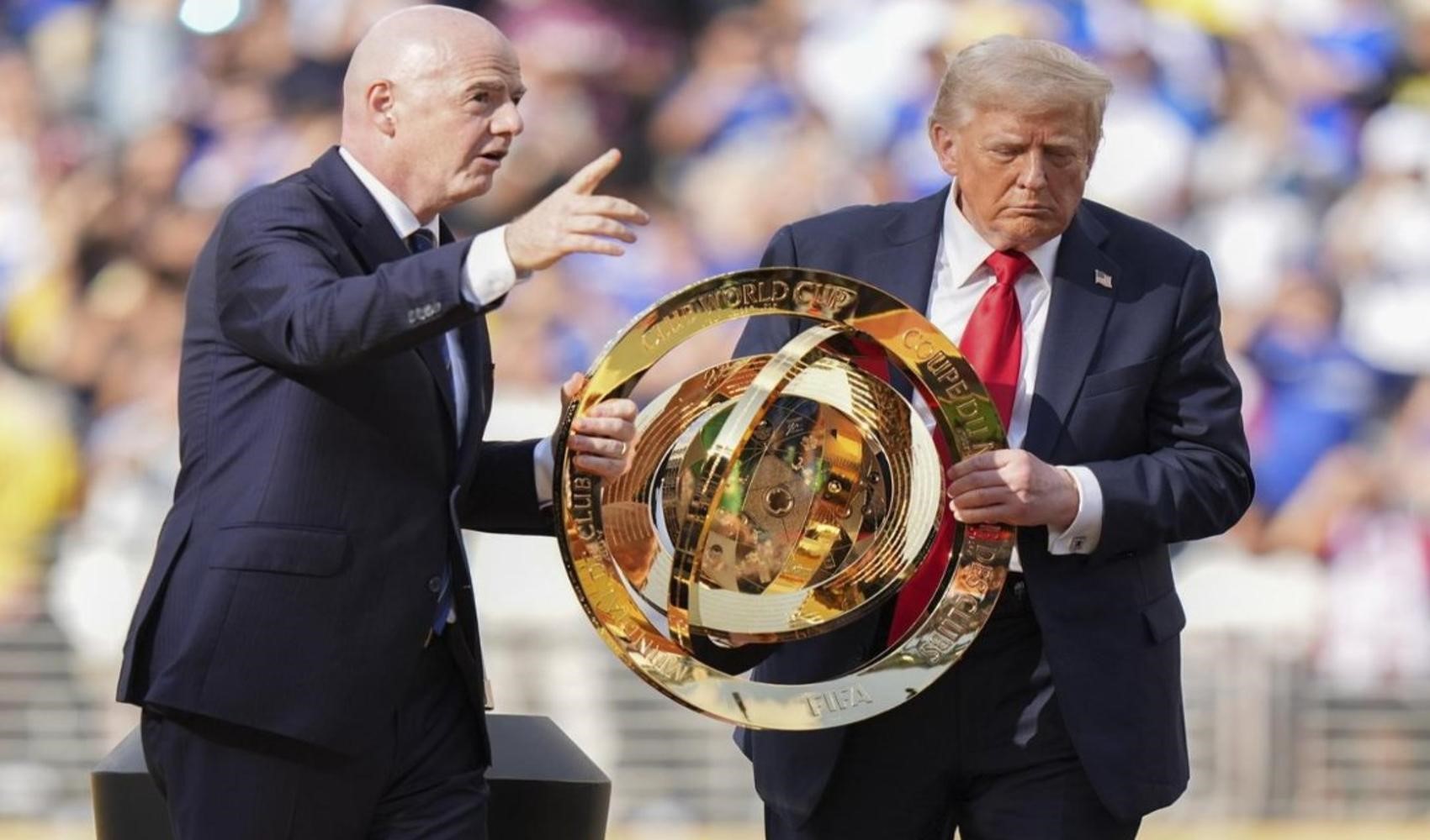 Gianni Infantino ve Donald Trump bir futbol kupasının yanında görülüyor.
