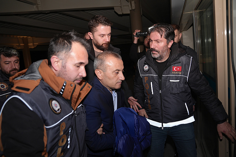 Polis ekipleri arasında götürülen Tuncay Sonel.