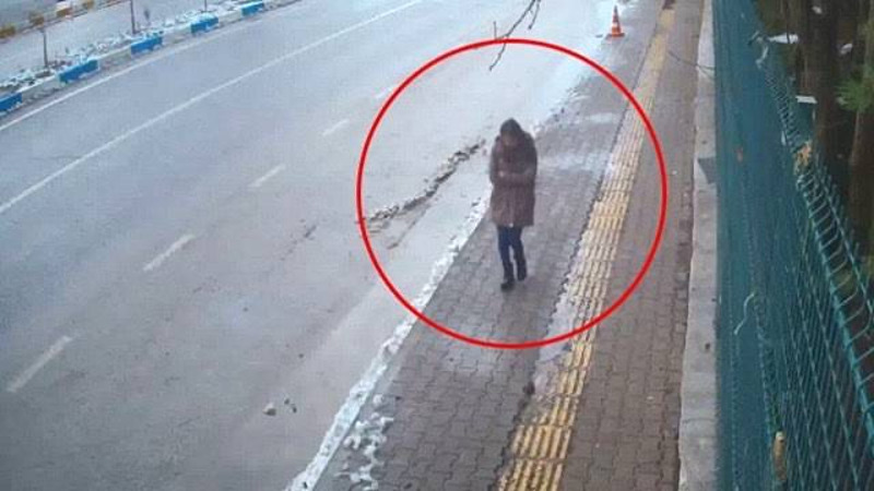 Kaldırımda yürüyen bir kişinin güvenlik kamerası görüntüsü.