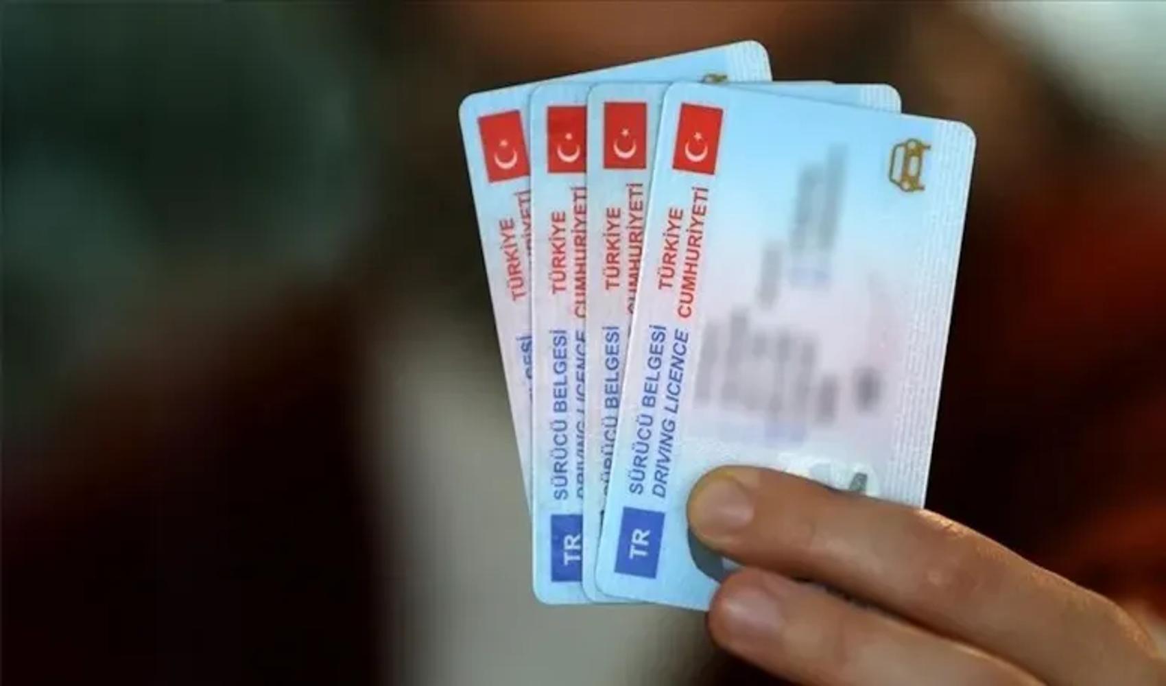 Una persona che tiene in mano le patenti di guida della Repubblica di Turchia.