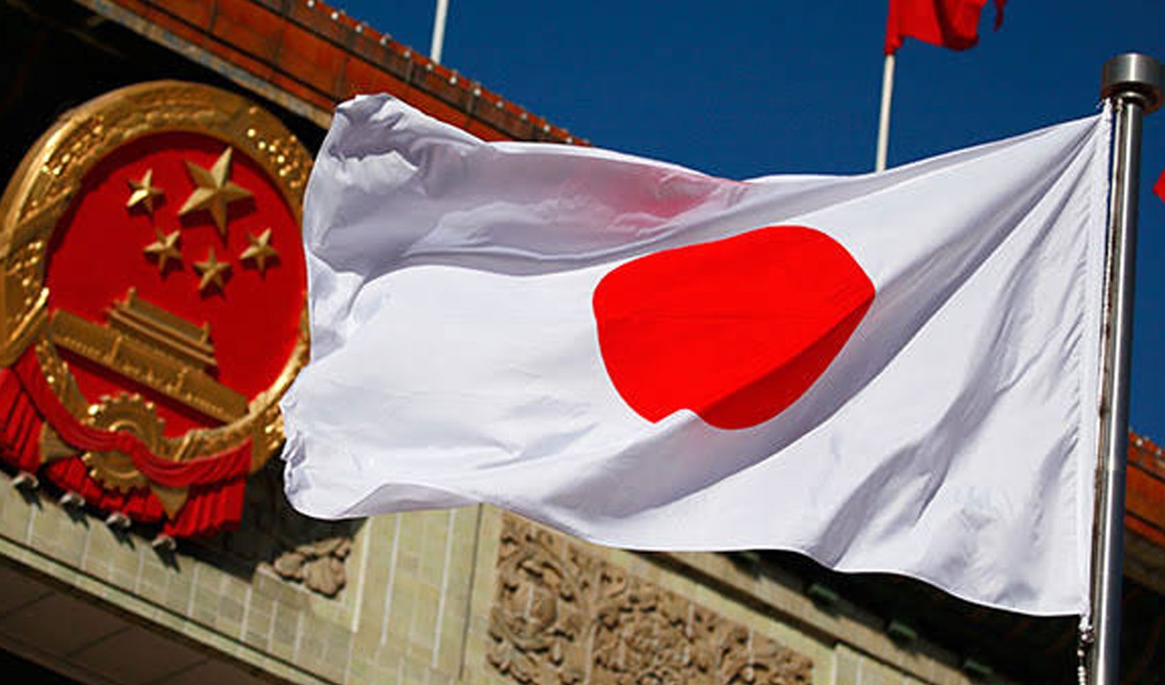 Bir binanın önünde dalgalanan Japonya bayrağı görülüyor.