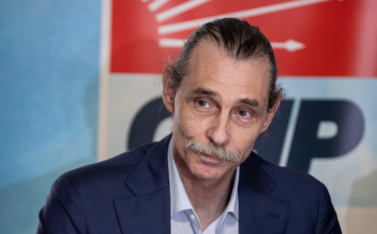 Erdal Beşikçioğlu’nun CHP logolu arka plan önünde çekilmiş fotoğrafı.