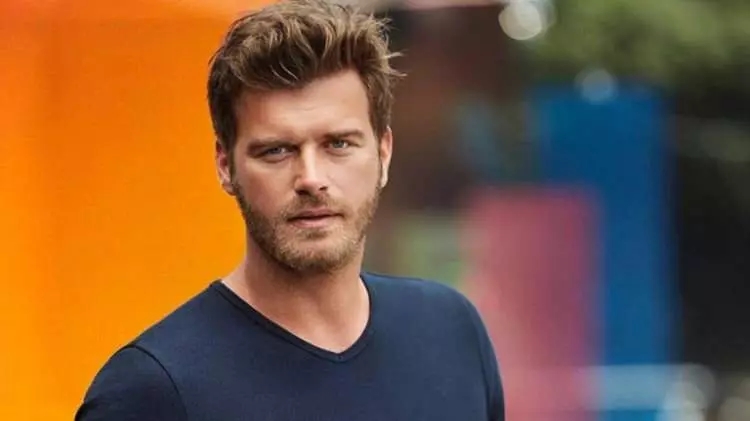 Kıvanç Tatlıtuğ’un renkli arka plan önünde çekilmiş portresi.