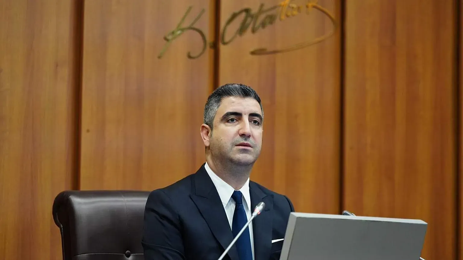 Gökhan Yüksel belediye meclisi salonunda kürsüde otururken görülüyor.