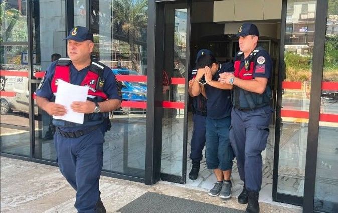 Jandarma ekiplerinin şüpheliyi adliye çıkışında götürdüğü anı gösteren fotoğraf.