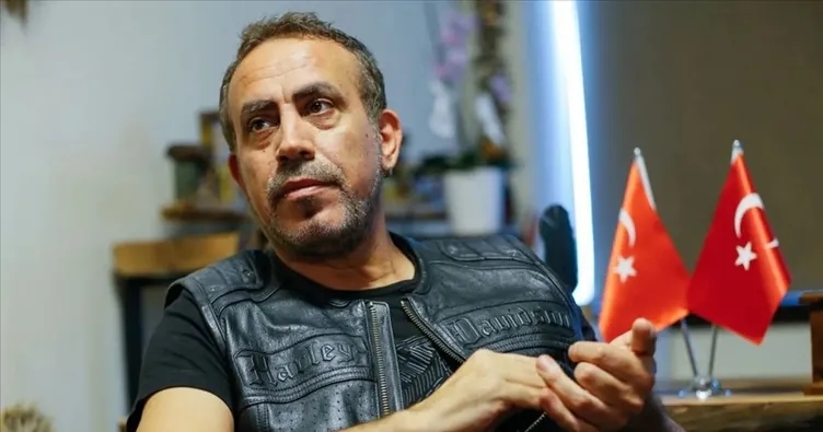 Haluk Levent’in masa başında Türk bayrakları önünde çekilmiş fotoğrafı