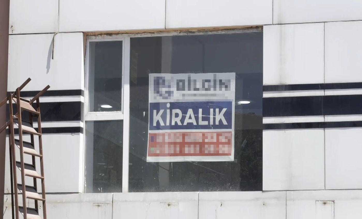 Boş bir iş yerinin camında kiralık ilanı görülüyor.