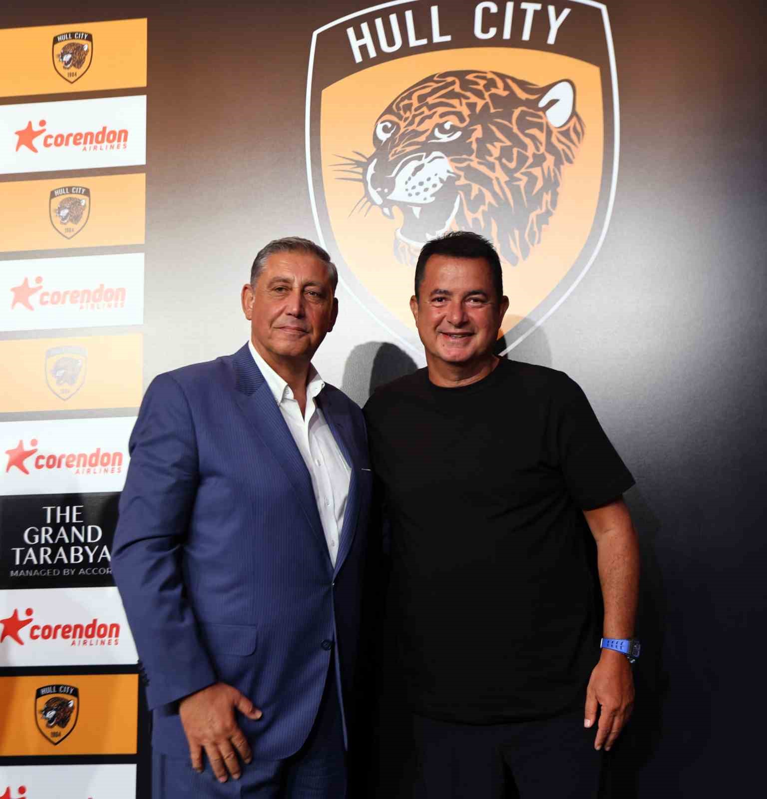 Yıldıray Karaer ve Acun Ilıcalı, Hull City logosunun önünde birlikte poz veriyor.