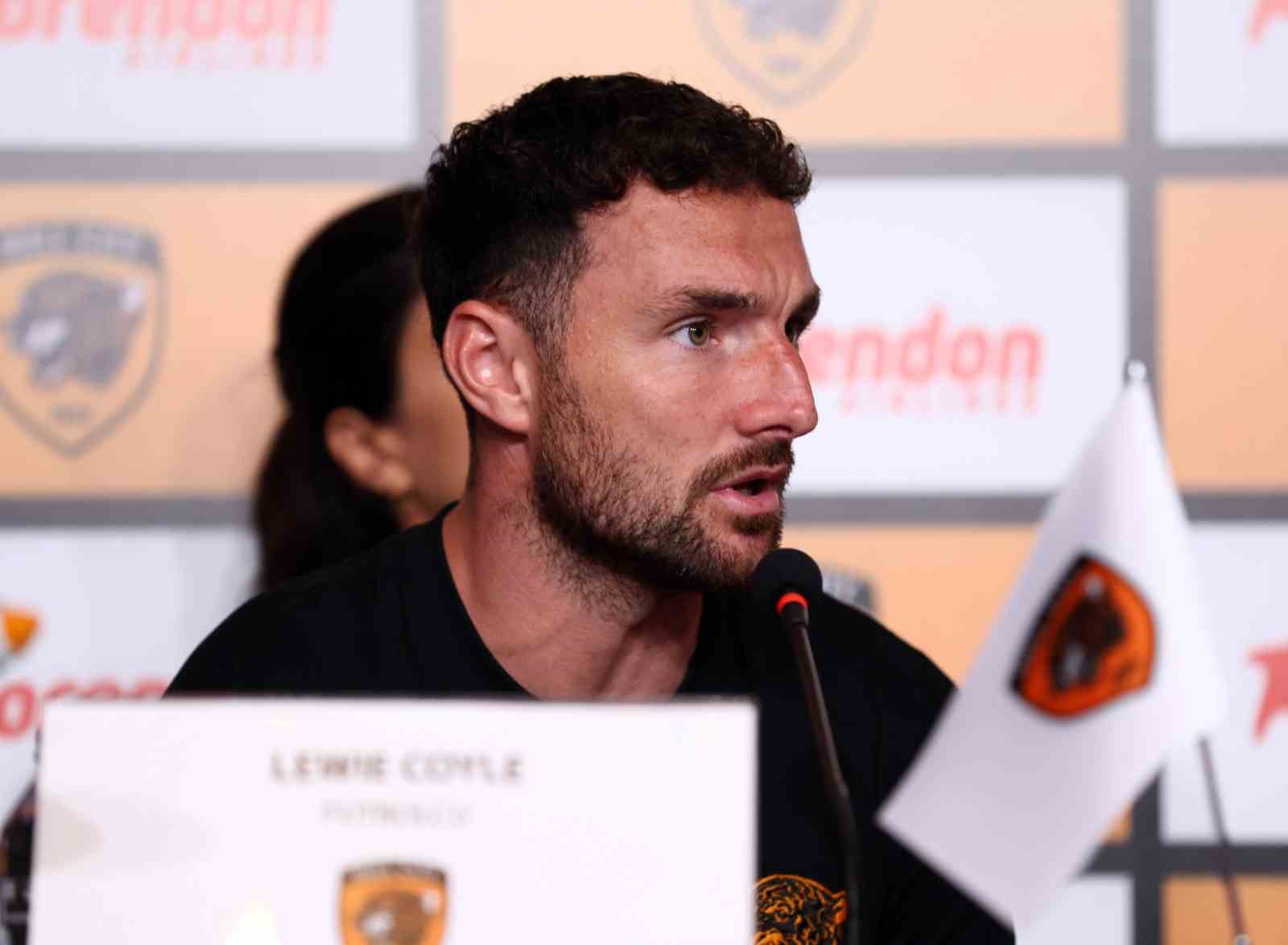 Lewie Coyle basın toplantısında mikrofon başında konuşuyor.