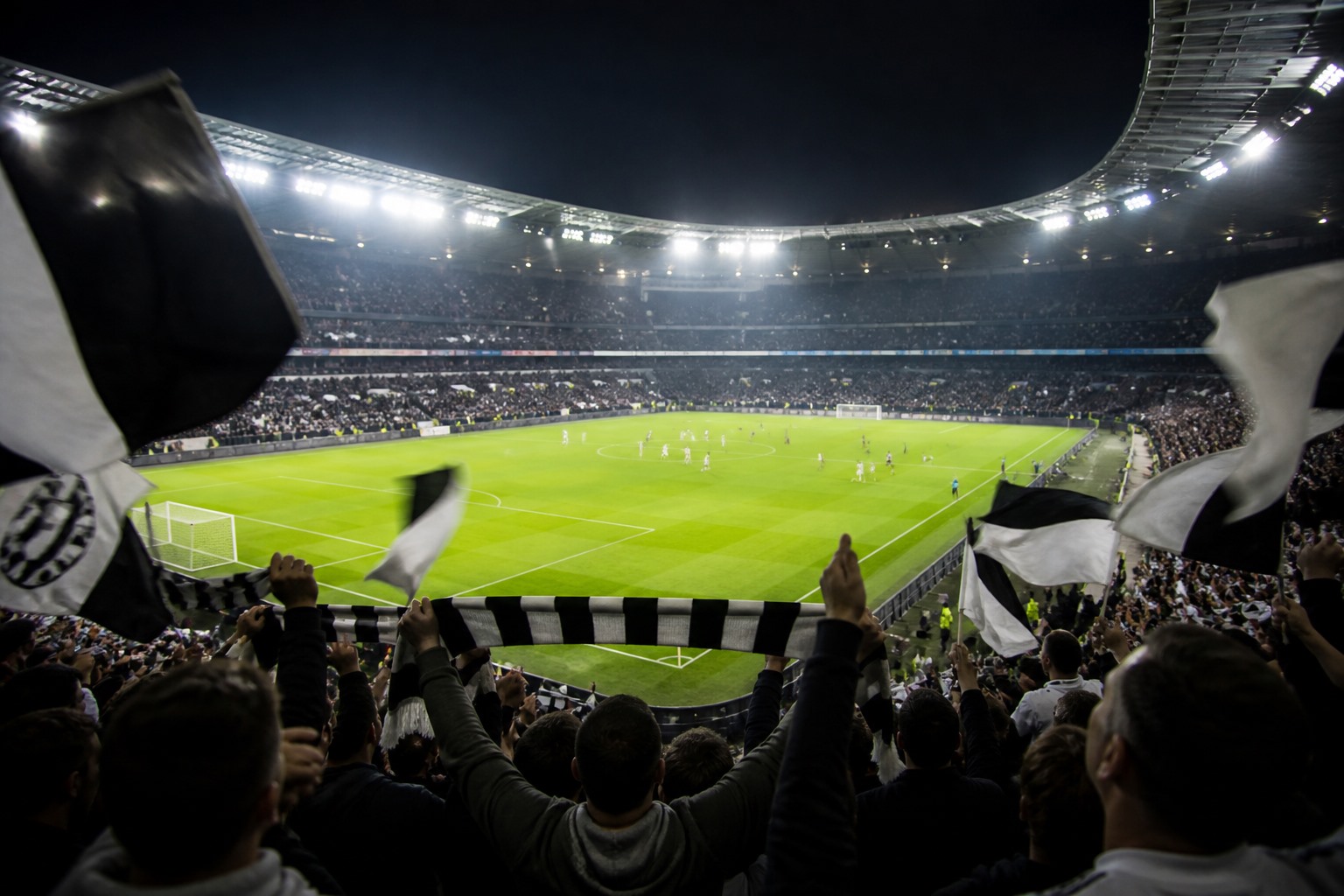 Işıklandırılmış modern bir futbol stadyumunda Avrupa kupası eleme maçı atmosferini yansıtan temsili görsel.